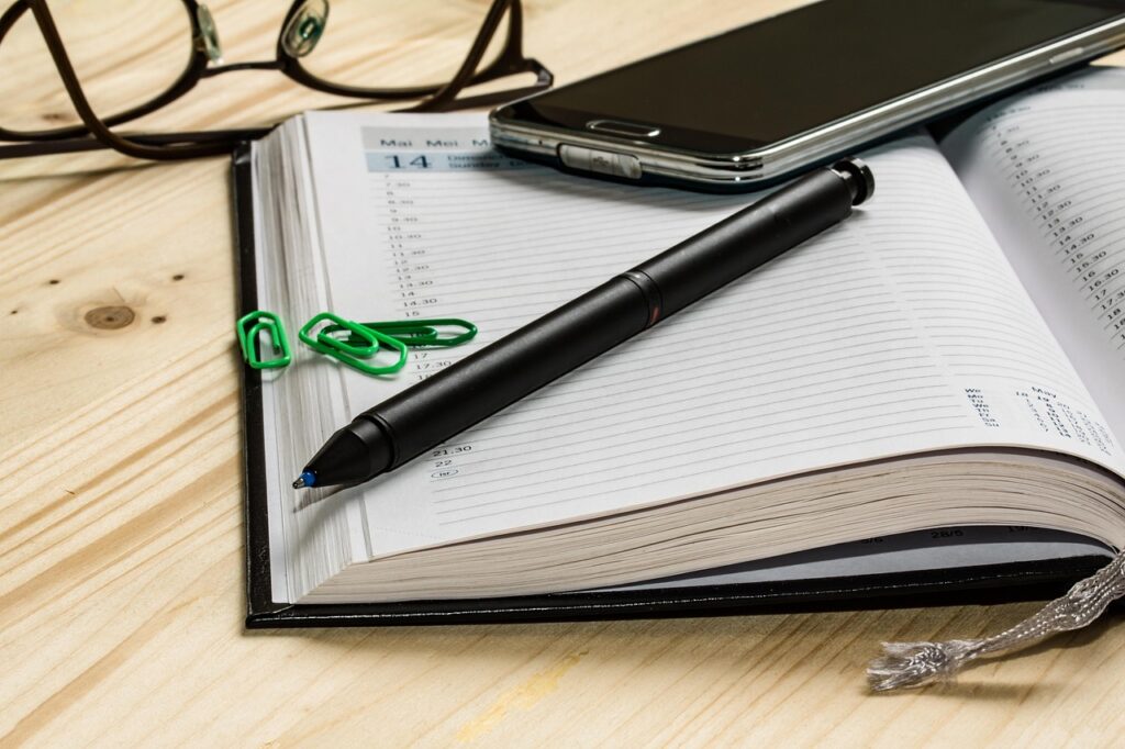 Agenda aperta con penna e smartphone