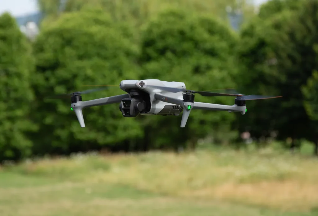DJI Air 3 in volo davanti a una siepe