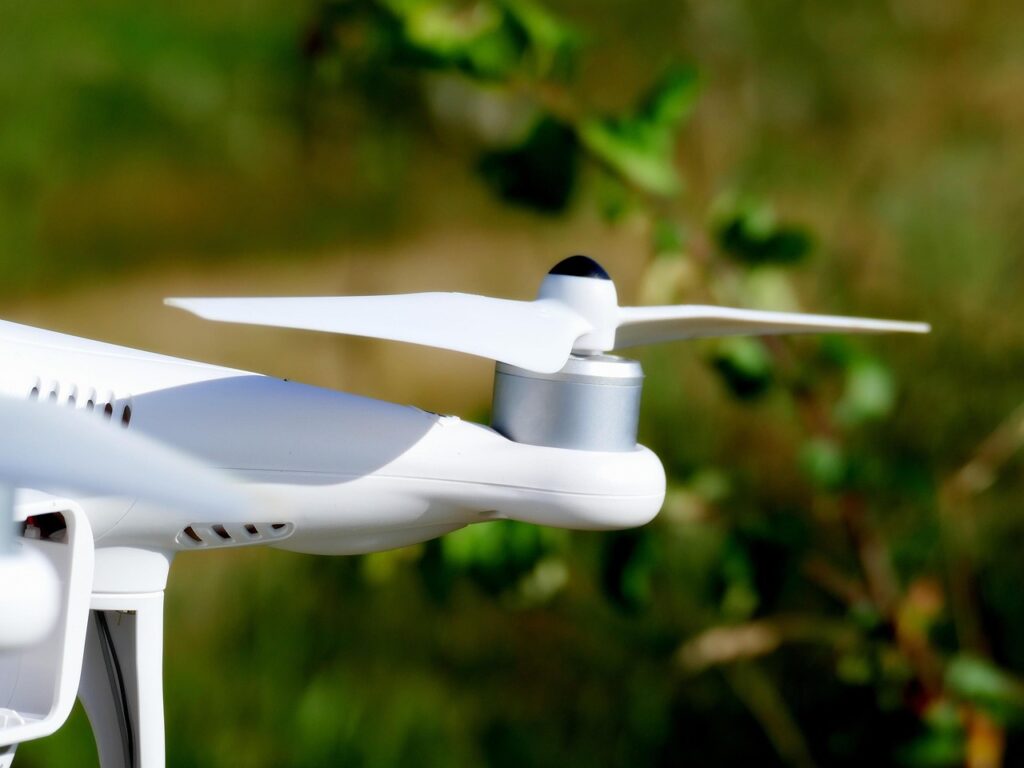 Drone bianco in volo vicino alla vegetazione