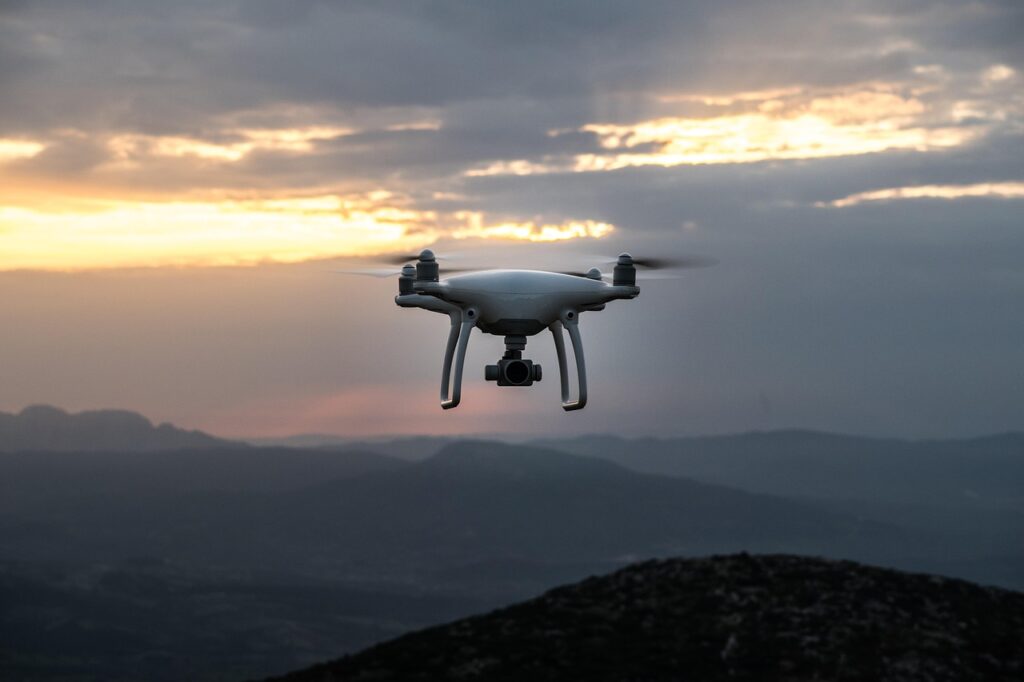 Drone in volo sopra le montagne all’alba