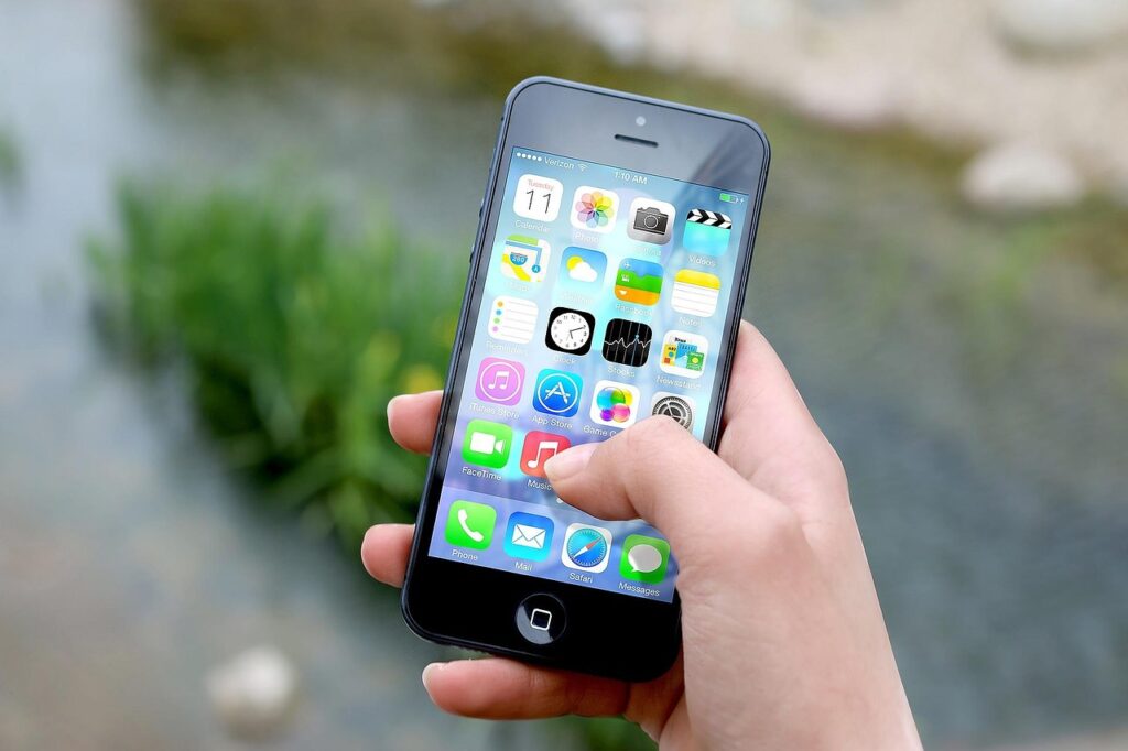 Smartphone in mano davanti al verde